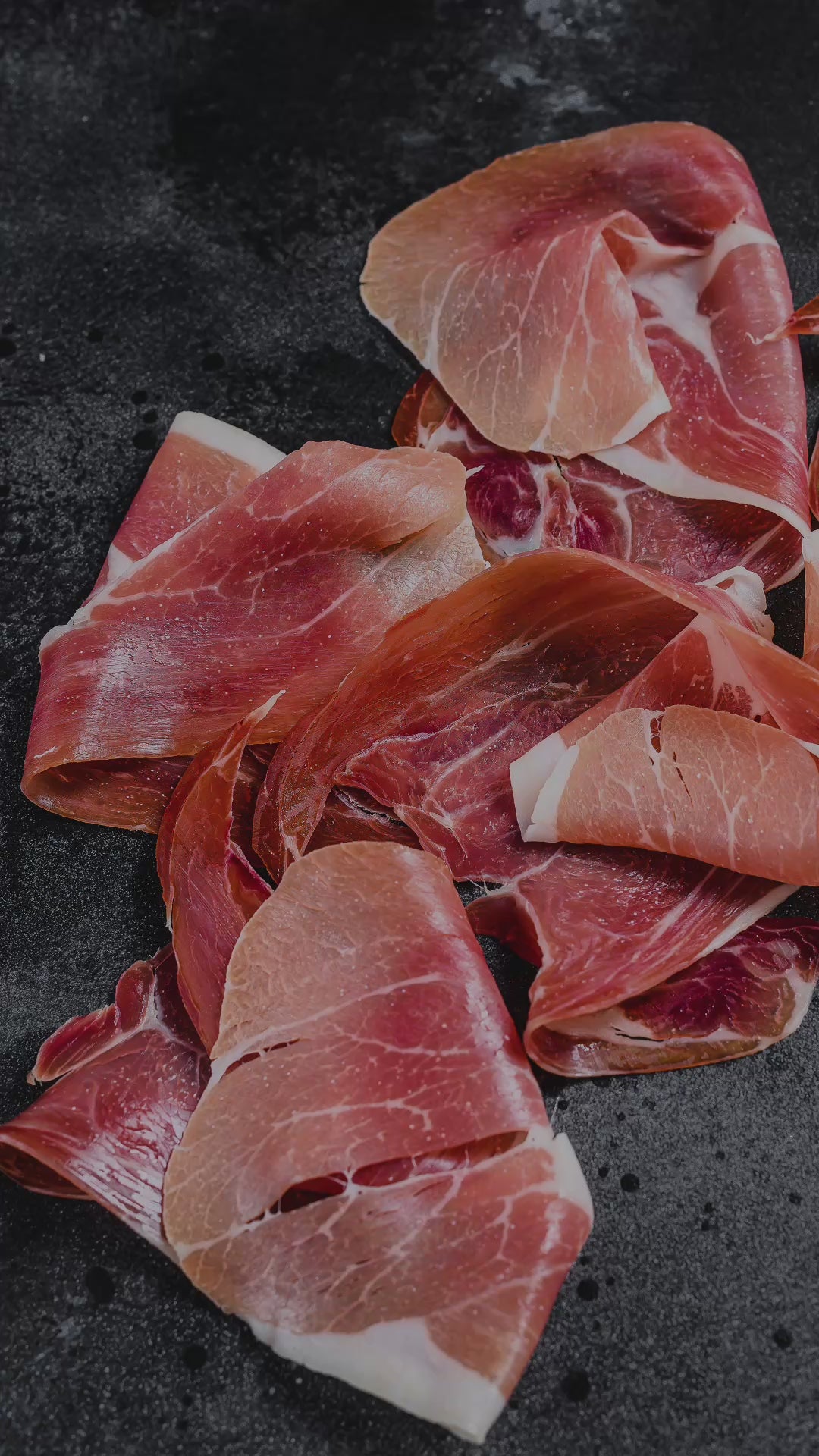 Verschiedene Delikatessen wie Schinken (Jamón), Käse (Queso), Wein (Vino) und Olivenöl (Aceite de Oliva).